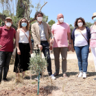 L'alcalde de Flix, Francesc Barbero, acompanyat de regidors, davant de l'olivera que han plantat en l'acte de commemoració del primer aniversari de l'incendi de la Ribera d'Ebre.