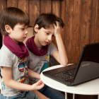 Dos niños ante un ordenador portátil.