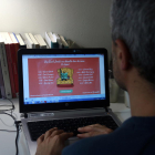 Una persona observa las propuestas online de los autores del Grupo 62 por Sant Jordi.