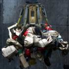 El gancho de una grúa elevando varias bolsas de residuos sanitarios para introducirlas al horno de la incineradora Sirusa de Tarragona.