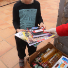 Plano medio de un niño recibiendo libros de la mano de los técnicos de Cruz Roja Juventud a Tarragona