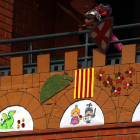 Pla contrapicat d'un nen disfressat de cavaller Sant Jordi al seu balcó engalanat per a la Diada a Tortosa.