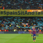 Cartel de Tsunami Democrático con el lema 'Spain, sit and talk!' al inicio del clásico en el Camp Nou detrás de los jugadores.