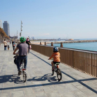 Una familia circula en bici por el paseo marítimo de Barcelona este domingo.