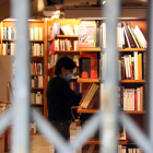 Una librería con la persiana bajada, pero con sus empleados trabajando por Sant Jordi.