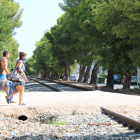 Una pareja atravesando la antigua vía del tren a Miami Platja.