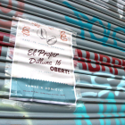 Un cartell en la persiana d'un local al centre de Sabadell anunciant la reobertura, el 22 de novembre de 2020