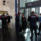 Varios viajeros del AVE mostrando certificados de desplazamiento a agentes de los Mossos d'Esquadra durante un control de movilidad.