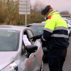 Un agent dels Mossos d'Esquadra comprovant el certificat que li mostra un conductor en un control de trànsit a la T-11, a Tarragona,