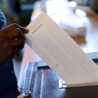 Una urna en el momento en que un ciudadano deposita su voto en unas elecciones.