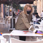 Primer pla d'una restauradora netejant una taula al carrer August de Tarragona.