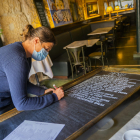Marta Ferré escriu les propostes gastronòmiques que ofereix l'establiment Cappuccino de la plaça de la Font.