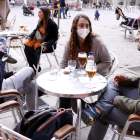 Unos jóvenes toman una cerveza en una terraza en la plaza de la Virreina.