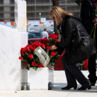 Una afectada per la tragèdia de Germanwings deixant una rosa al monument de la T2 del Prat, durant l'acte d'homenatge a les víctimes en el segon aniversari del succés.