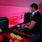 Un DJ posant música en un bar musical.