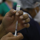Una trabajadora de la salud preparando una dosis de una vacuna.