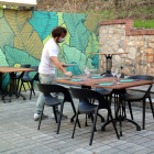 Plano general del copropietario del restaurante Botànic de Tortosa poniendo mesas en la terraza del establecimiento antes de la reapertura del mediodía.