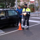 Pla general d'un conductor mostrant la documentació i els certificats de mobilitat a un agents dels Mossos en el control a la intersecció de l'N-340 a les Cases d'Alcanar.