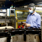Un treballador inspecciona un pot de Nescafé al costat d'una de les línies de producció de la fàbrica de Girona.
