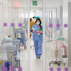 Vista de una profesional sanitaria a través de unas puertas del nuevo espacio polivalente del Hospital de Bellvitge