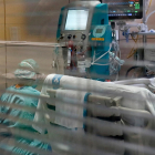 Una enfermera mirándose una máquina con el filtro Seraph 100 después de ser utilizado para filtrar la sangre de un paciente con covid-19 ingresado en el UCI de Vall d'Hebron.