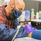Carlos Latorre, de l'estudi Chopper Ink Tattoo, tatuant el turmell d'una noia al seu local del Cós del Bou la setmana passada.