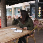 Pla mitjà d'una dona prenent un cafè en un bar del centre de Tarragona.