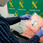 Imatge policial d'un agent de la Guàrdia Civil intervenint diversos paquets amb pastilles d'MDMA trobats entre l'equipatge d'un conductor.