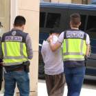 La policía se lleva a un detenido de una tienda de telefonía de la calle de la Rutlla de Girona.
