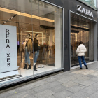 Una compradora delante de una tienda Zara cerrada en el Portal de l'Àngel de Barcelona.
