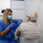 Una infermera vacuna un home en un dels box del punt de vacunació massiva habilitat a Fira de Barcelona.