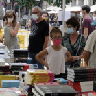 Compradors amb mascaretes mirant llibres al Sant Jordi d'estiu de Girona.
