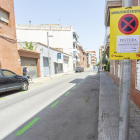 Imagen de la calle Robert Aguiló del barrio del Milagro con la zona verde de estacionamiento pintada.