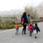 L'educadora i els infants de l'espai familiar d'autogestionat de La Muntanya d'Arbolí caminat pel poble d'esquenes.