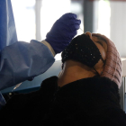 Una mujer sometiéndose a la extracción de muestras para un test|tiesto de antígenos.