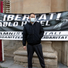 Plano abierto donde se puede ver al rapero Pablo Hasél delante de una pancarta que pide su libertad.