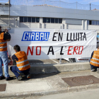 Els treballadors de Girbau penjant una pancarta a Vic