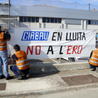 Los trabajadores colgando una pancarta en Vic.