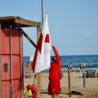 El personal de Cruz Roja izando la bandera.