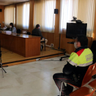 Plan|Plano abierto del hombre condenado por abusos sexuales a menores, sentado en la sala de vistas de la Audiencia de Tarragona, con dos agentes de los Mossos d'Esquadra en primer término