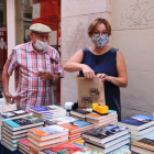 Un cliente comprando un libro en la parada de la librería Gaudí de Reus en el Sant Jordi de verano.