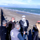 Un grupo de vecinos de Riumar en la zona norte de la playa, donde el mar se aproxima a las pasarelas de madera.