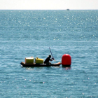 Una embarcació al costat d'una de les boies que engoleixen microplàstics instal·lades a les platges de l'Ampolla.