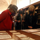 Pilarín Bayés y la consellera Àngels Ponsa, contemplan la obra original de la primera en la Biblioteca de Cataluña.