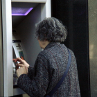Imagen de archivo de una persona utilizando un cajero automático.