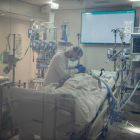 Un metge atenent amb un pacient amb covid-19 a l'Àrea de Vigilància Intensiva (AVI) de l'Hospital Clínic de Barcelona.