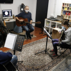 Albert Gilabert, professor de guitarra de l'aula El Traster de Mollerussa, fent classe amb dos alumnes, en la represa de les activitats extraescolars.