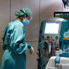 Una enfermera mirándose una máquina que ha filtrado la sangre de un paciente con covid-19 ingresado en la UCI de Vall d'Hebron.