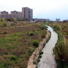 Un tram del riu Francolí al seu pas per la ciutat de Tarragona amb un mur empedrat i molt poca vegetació de ribera.
