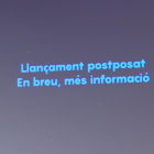 Una pantalla al CosmoCaixa informa que s'ha posposat el llançament de primer satèl·lit de la Generalitat
